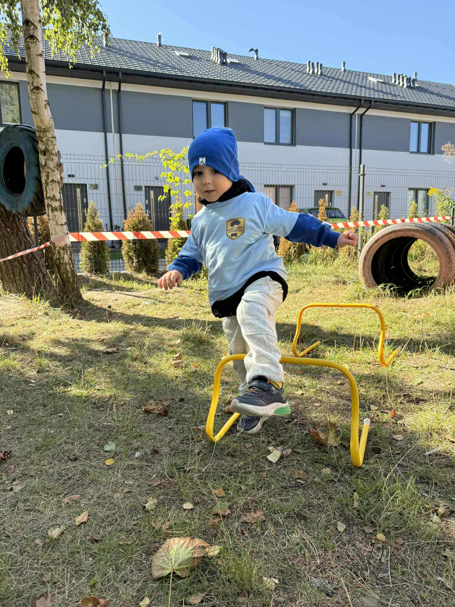 Dziecko pokonuje tor przeszkód na przedszkolnym terenie